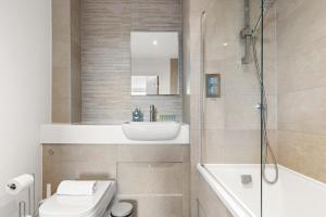 a bathroom with a toilet and a sink and a shower at Sleek & Stylish Apartment in the Best Area in Beckenham +25 photos