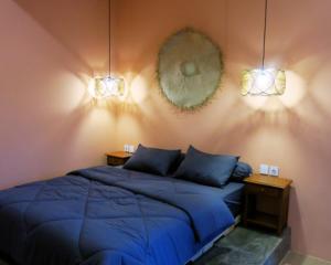 a bedroom with a blue bed and a mirror at apartement Puri 2 in Jimbaran