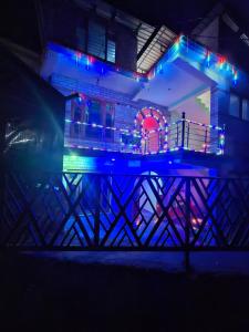 a building with blue and purple lights on it at Trippy Homestay in Kasol