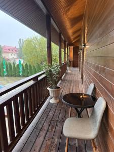 a wooden porch with a table and chairs on it at Turnul ALB in Costeşti