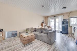 a living room with a gray couch and a kitchen at Ride by the Sea Guesthouse in Koudekerke