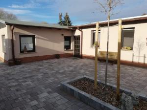 una casa con un árbol delante en Wohnung am Waldesrand für Monteure, en Gräfenhainichen