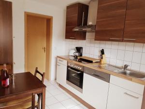 una cocina con fregadero y estufa horno superior en Wohnung am Waldesrand für Monteure, en Gräfenhainichen