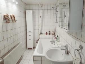 Un baño blanco con lavabo y bañera. en Wohnung am Waldesrand für Monteure, en Gräfenhainichen