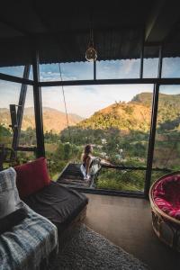 a woman sitting on a swing in front of a large window at Romance in Ella in Ella
