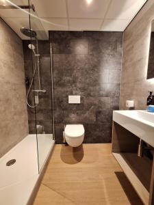 a bathroom with a toilet and a shower and a sink at Fletcher Hotel Apeldoorn in Apeldoorn +25 photos