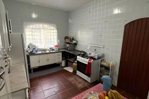 a kitchen with white tile walls and a stove top oven at Casa Alpe de Itapeva in Itapeva