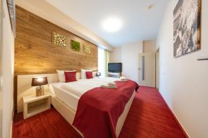 a bedroom with a large bed with a red blanket at Hotel CROCUS in Štrbské Pleso