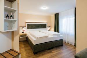 een slaapkamer met een groot wit bed en een raam bij Hotel Scheffler Lüneburg in Lüneburg