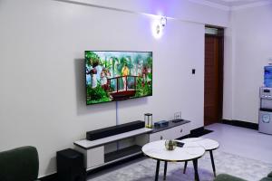a living room with a tv on a wall at Araka Homes in Nakuru