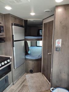 Una pequeña habitación con un pequeño frigorífico y una cocina. en Laqa comp Oman - مخيم لقى عُمان, 