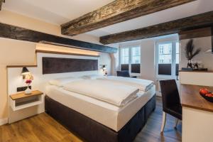 een slaapkamer met een groot bed en een bureau bij Hotel Scheffler Lüneburg in Lüneburg