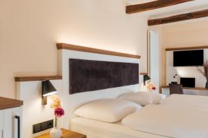 een slaapkamer met twee witte bedden en een schoolbord aan de muur bij Hotel Scheffler Lüneburg in Lüneburg