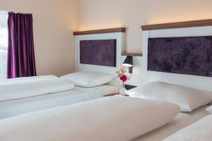 twee bedden in een hotelkamer met witte lakens bij Hotel Scheffler Lüneburg in Lüneburg +22 foto's