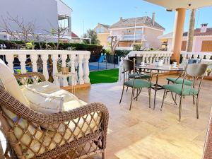 een terras met stoelen en een tafel op een balkon bij Villa en la Playa I 5BR I 5 WC I Piscina Privada in Sueca