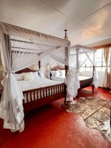 1 Schlafzimmer mit 2 Betten und Moskitonetzen in der Unterkunft Wild Amboseli Ndovu Cottage. in Amboseli-Nationalpark