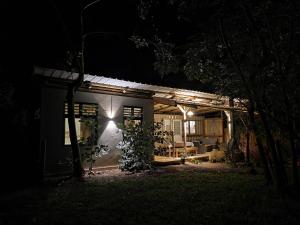 a house with lights on the side of it at night at Le Pavillon, at La Petite Ferme 2BRoom with private fireplace in Grand Sable +19 photos