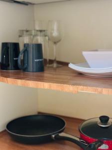 a black frying pan sitting on a wooden shelf at Relaxed Studio Near the Beach in Jan Thiel +8 photos