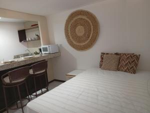 a small room with a bed and a kitchen at PIPAS BAY - Aparthotel Vista Mar in Pipa