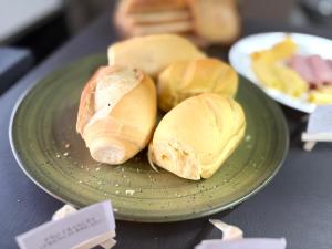 two sandwiches on a green plate on a table at Hotel Amazon In in Belém