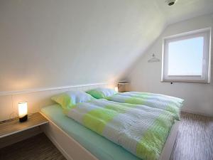 a bedroom with a bed with a window and a bed sidx sidx sidx at Ferienhaus Bleicken in Morsum