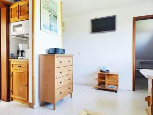 a room with a dresser and a tv on a wall at Ferienhaus Bleicken in Morsum