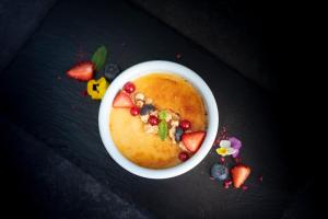 a bowl of food with fruit and berries on a table at Wyndham Wroclaw Old Town in Wrocław +48 photos
