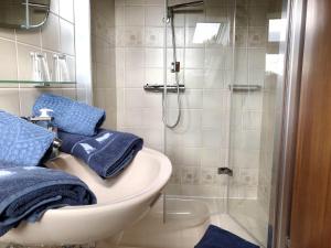 a bathroom with a sink and a shower with blue towels at Ferienwohnungen Morsum - Bleicken in Morsum +17 photos