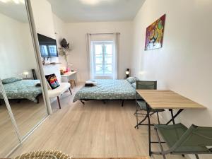 ein Wohnzimmer mit einem Bett und einem Tisch in der Unterkunft Hyper Centre de Vincennes - Métro 3 min in Vincennes