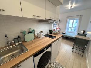 eine Küche mit Spüle und Waschmaschine in der Unterkunft Hyper Centre de Vincennes - Métro 3 min in Vincennes