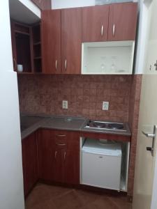 a small kitchen with wooden cabinets and a sink at TITO in Belgrade