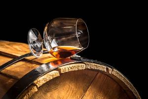 a glass of whiskey sitting on top of a barrel at Bed and Cèpes in Busserolles
