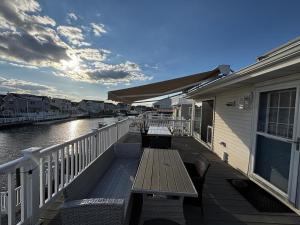 a wooden deck with a wooden bench on a balcony at Lagoon Front 4 Bedroom Beat The Crowds in Beach Haven West