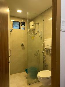 a bathroom with a glass shower with a toilet at Spring Nature Stay in Kashid +33 photos
