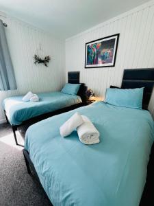 a bedroom with two beds with towels on them at Tigh Na Sealladh in Dunoon