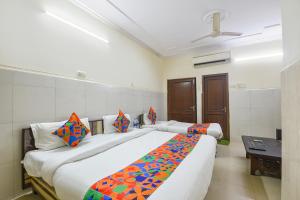 a bedroom with two beds with colorful pillows at FabHotel Shiv Palace in New Delhi
