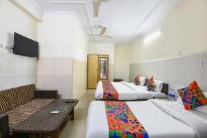 a hotel room with two beds and a couch at FabHotel Shiv Palace in New Delhi