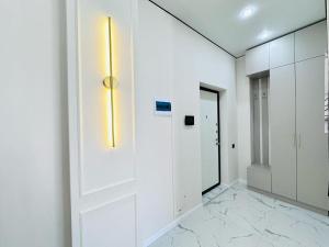 un couloir aux murs blancs et une porte lumineuse dans l'établissement Уютная евродвушка возле Mega Silkway!, à Zhezdi 5 autres photos