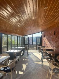 a dining room with tables and chairs and windows at Comfortable House the city centr in Kutaisi