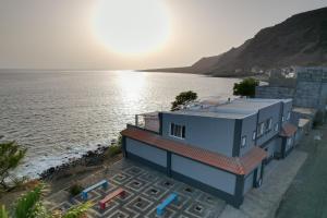 a house next to a body of water at B&B Casa Boho in Telha