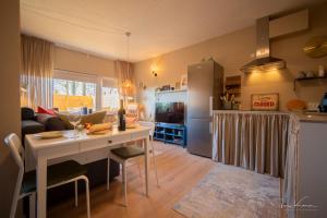 a kitchen and living room with a table and a refrigerator at FeWo Lille Lægehus in Hjørring