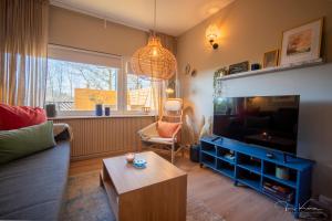 a living room with a couch and a tv at FeWo Lille Lægehus in Hjørring