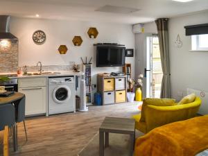 a living room with a kitchen and a living room with a stove at The Secret Luxury Apartment in New Romney