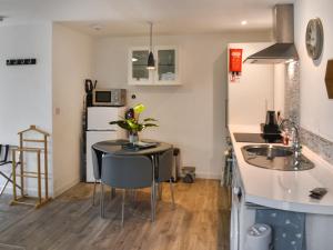 a kitchen with a sink and a table with chairs at The Secret Luxury Apartment in New Romney