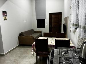 una sala de estar con un sofá, una mesa y sillas en Prehenn Beach House com Piscina, en Itapoa