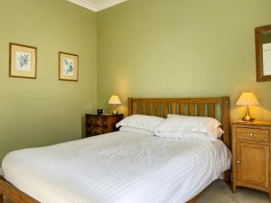 a bedroom with a bed with two night stands and two lamps at Hillcrest in Pickering +8 photos