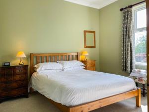 a bedroom with a bed and two lamps and a window at Hillcrest in Pickering
