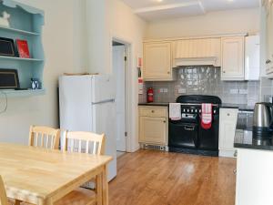 a kitchen with a table and a white refrigerator at Hillcrest in Pickering