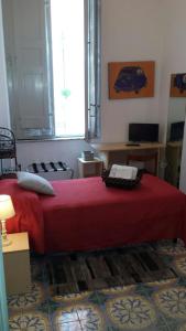 a bedroom with a bed with a red blanket and a window at B&B Centro Storico 900 in Palmi