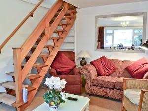ein Wohnzimmer mit Treppe und Couch in der Unterkunft Cedars in Fordwich